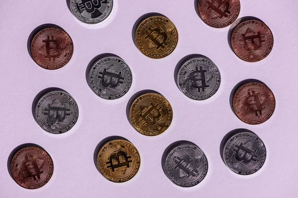 Vista superior de varios bitcoins arreglados sobre fondo púrpura - foto de stock