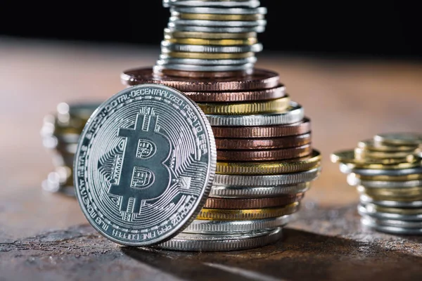 Selective focus of silver bitcoin and piles of bitcoins behind — Stock Photo