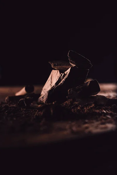 Vista de primer plano de trozos de chocolate sobre fondo negro - foto de stock