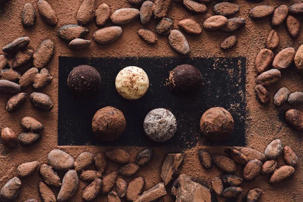 Vista dall'alto di tartufi e fave di cacao ricoperte di cioccolato grattugiato — Foto stock