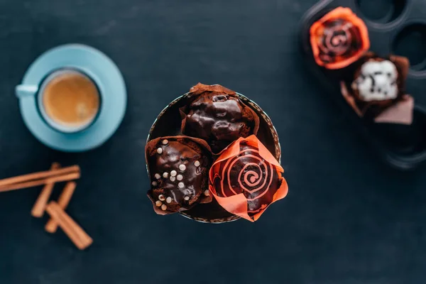Vue de dessus des cupcakes sucrés aux pépites de chocolat servis avec du café noir — Photo de stock