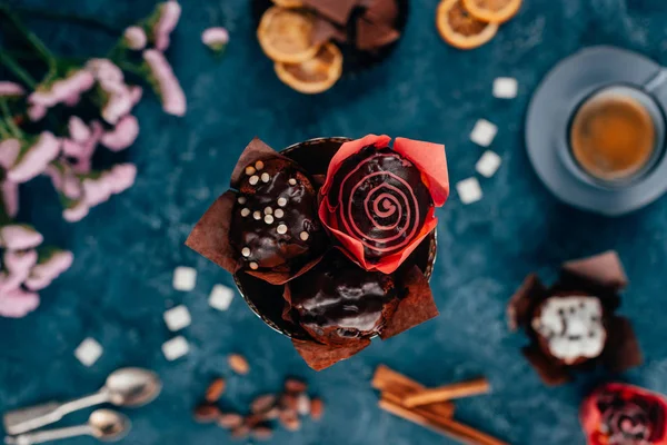 Draufsicht auf Schokoladenmuffins und Tasse Kaffee auf blauem Hintergrund — Stockfoto