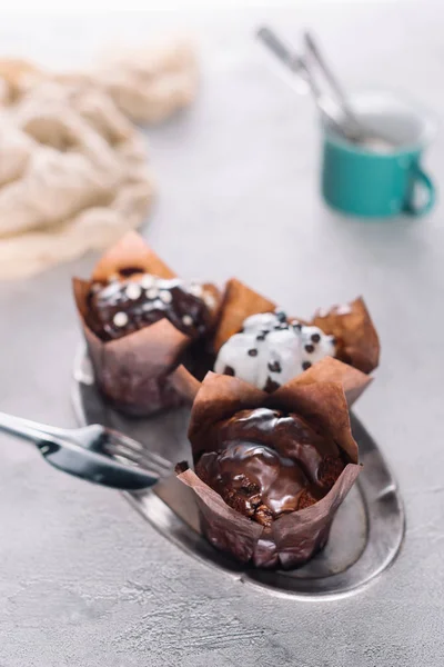 Delicious muffins with glaze served on tray with cutlery — Stock Photo