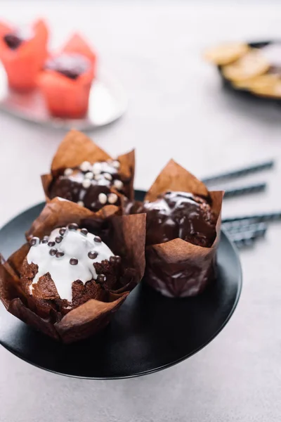Muffins au chocolat sucré avec glaçure servis sur assiette — Photo de stock