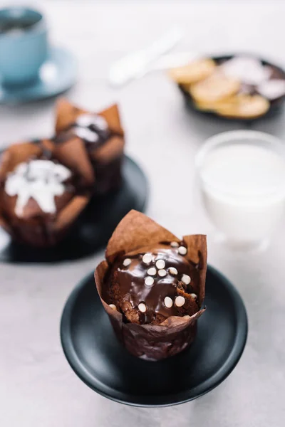 Muffin al cioccolato dolce con bicchiere di latte sul tavolo — Foto stock