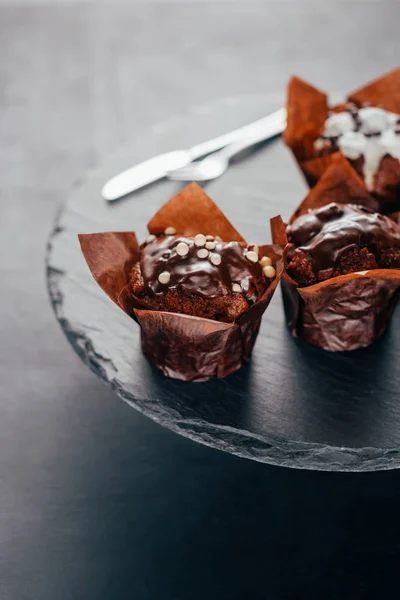 Delicioso muffin com esmalte no quadro de ardósia escuro — Fotografia de Stock