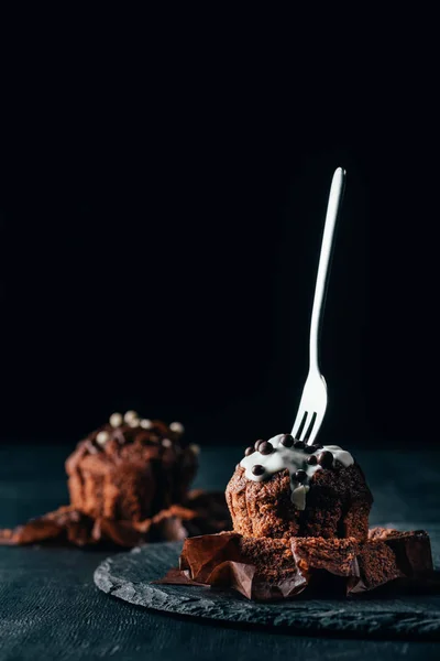 Süße Cupcakes mit Schokoladenchips und Gabel auf dunklem Hintergrund — Stockfoto