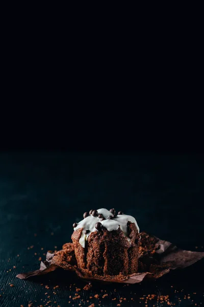 Süßer Schokoladen-Muffin mit Glasur auf dunklem Hintergrund — Stockfoto