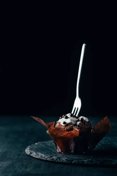 Dolce muffin al cioccolato con forchetta argento su sfondo scuro — Foto stock