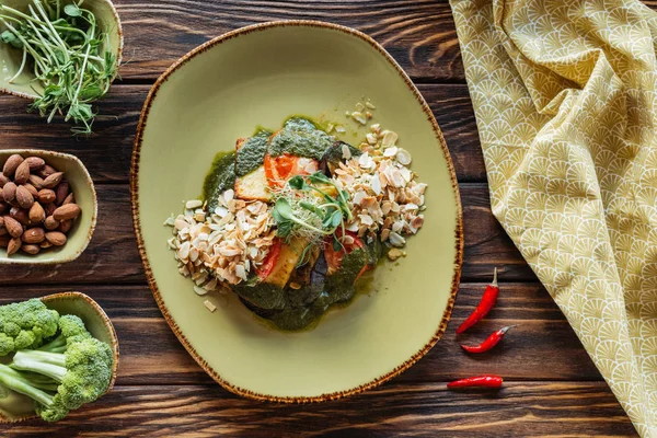 Piatto giaceva con insalata vegetariana, ingredienti in ciotole e biancheria su tavolo in legno — Foto stock