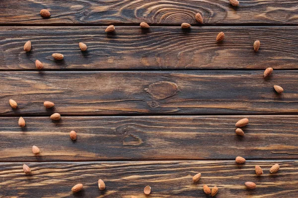 Top view of arranged almonds on wooden surface — Stock Photo