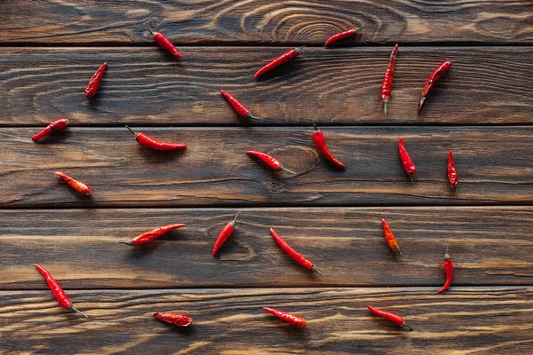 Top view of arranged chili peppers on wooden surface — Stock Photo