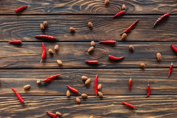 Quadro completo de arranjo de pimentas e amêndoas na superfície de madeira — Fotografia de Stock