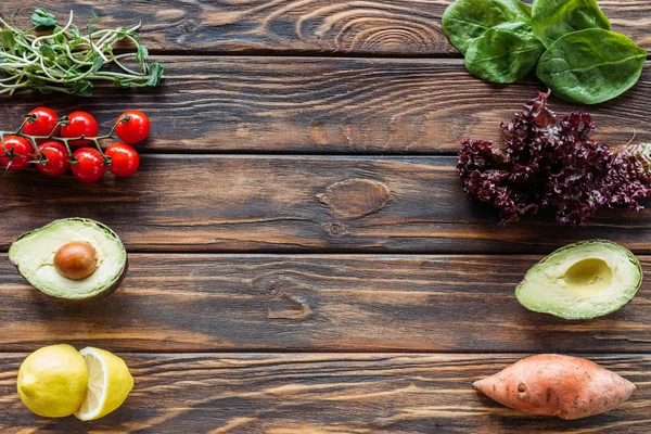 Vista superior de la disposición de verduras frescas y maduras en la superficie de madera - foto de stock