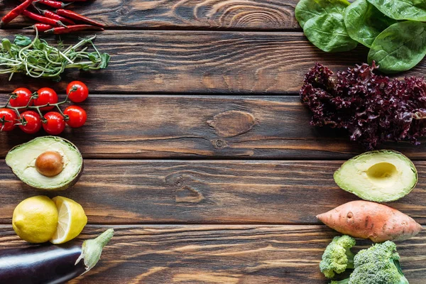 Vista superior de la disposición de verduras frescas y maduras en la superficie de madera con espacio de copia - foto de stock