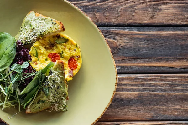 Vista dall'alto dell'insalata vegetariana con spinaci e germogli sul piatto sul tavolo di legno — Foto stock