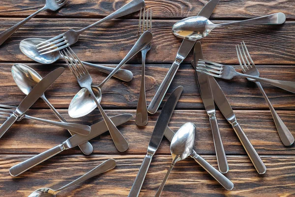 Top view of arranged steel cutlery on wooden tabletop — Stock Photo