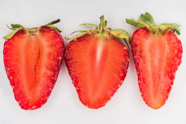 Trois moitiés de fraises sur fond blanc — Photo de stock