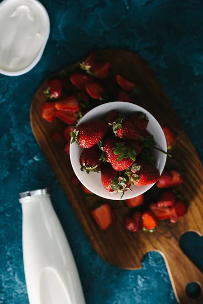 Fragole estive e bottiglia di latte sul tavolo blu — Foto stock