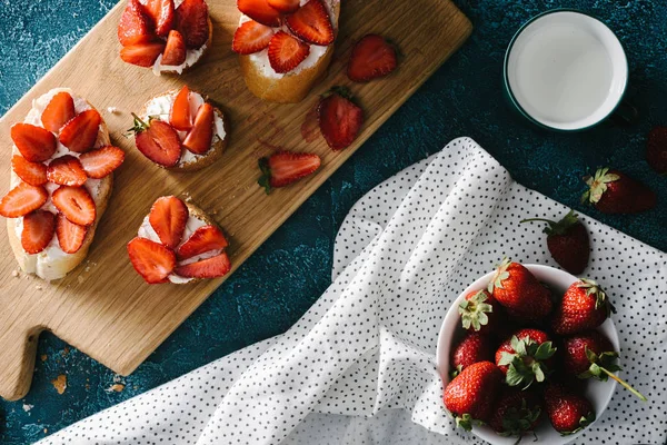 Pane con crema di formaggio e fragole crude in tavola con tovaglia — Foto stock