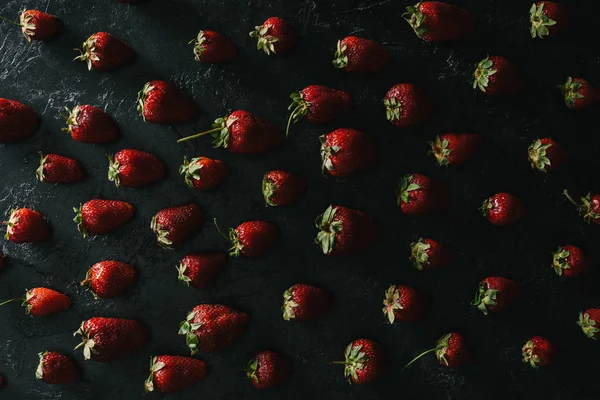 Vue de dessus des fraises mûres d'été sur fond sombre — Photo de stock