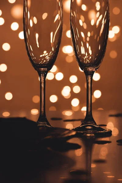 Close up view of empty glasses and confetti on tabletop — Stock Photo