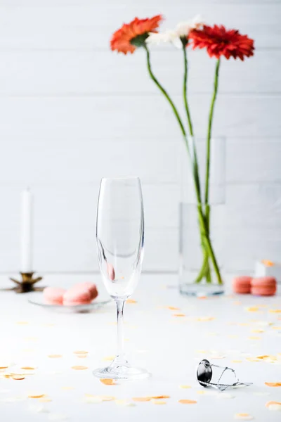 Selective focus of empty glass with bouquet of gerbera flowers on grey background — Stock Photo