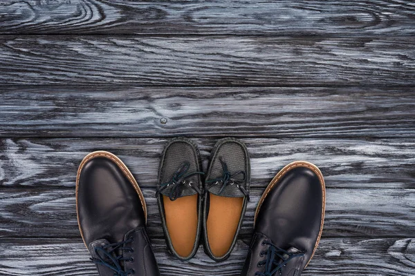 Vista superior de los zapatos del padre y del cabrito en la mesa de madera, concepto feliz del día del padre - foto de stock