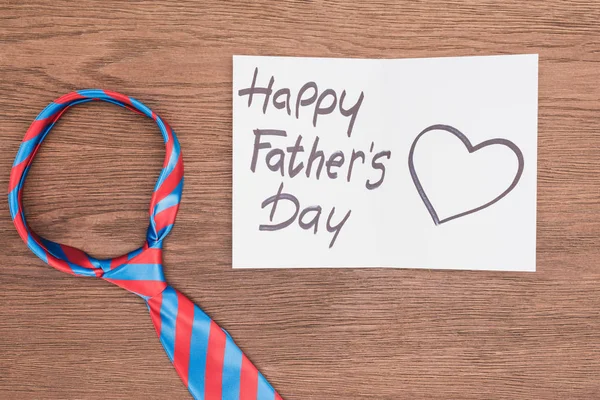 Top view of vivid tie with Happy fathers day greeting card on wooden surface — Stock Photo