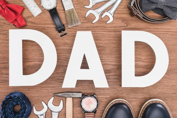 Vista superior de las letras DAD rodeadas de atribución de los padres en la superficie de madera, concepto del día del padre feliz - foto de stock