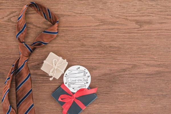 Top view of tie with gifts and Happy fathers day greeting on wooden surface — Stock Photo