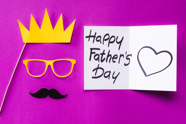 Vista dall'alto del volto del re con confezione regalo con biglietto di auguri Happy father day sulla superficie rosa — Foto stock