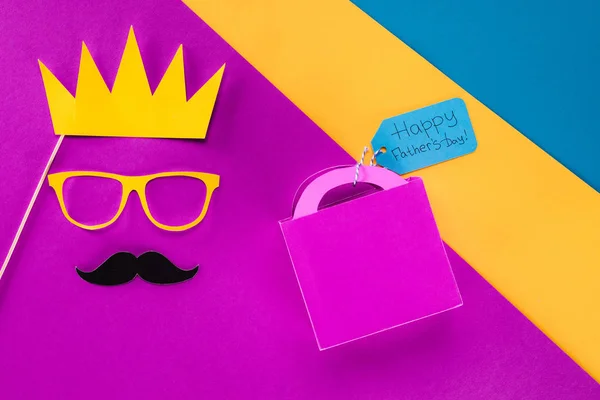 Vista dall'alto del volto del re con confezione regalo con tag giorno Happy Padri sulla superficie colorata — Foto stock