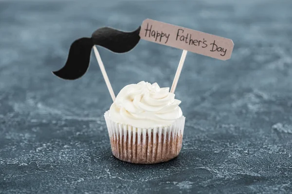 Leckere Cupcake mit Schnurrbart-Zeichen und Happy Vatertag Inschrift auf Betonoberfläche — Stockfoto