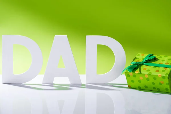 Caixa de presente verde perto de pai inscrição feita de letras brancas em verde, conceito feliz dia dos pais — Fotografia de Stock