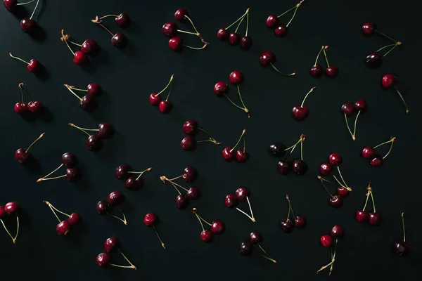 Top view of fresh ripe red sweet cherries on black background — Stock Photo
