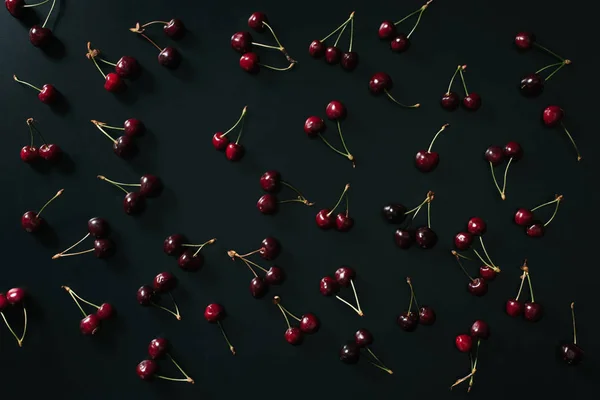 Vista superior de cerezas dulces rojas maduras frescas sobre fondo negro - foto de stock