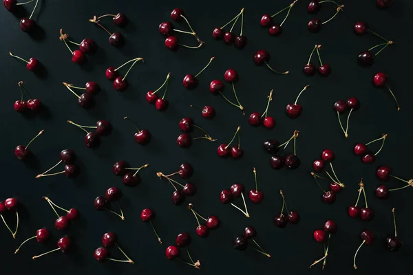 Vue de dessus des cerises douces mûres rouges sur fond noir — Photo de stock