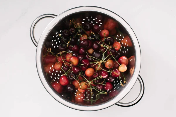 Vista superior de cerezas frescas maduras dulces y saludables en colador aislado en blanco - foto de stock