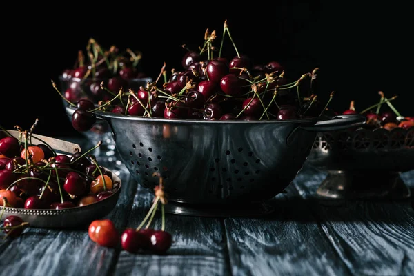Ripe sweet healthy cherries in colander on wooden table — Stock Photo