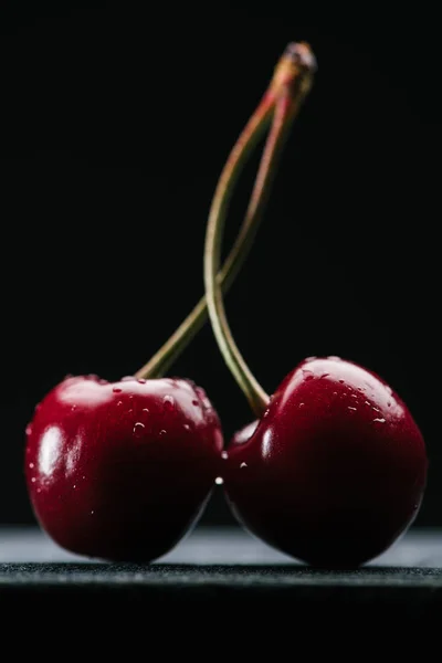 Close-up view of fresh wet sweet cherries on black — Stock Photo