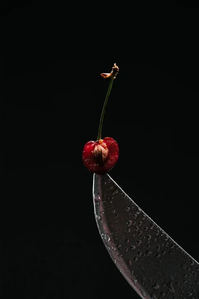 Vue rapprochée de la moitié de cerise douce mûre sur couteau isolé sur noir — Photo de stock