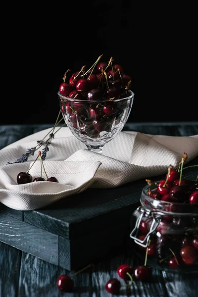 Vista close-up de cerejas frescas maduras doces em utensílios de vidro na mesa de madeira — Fotografia de Stock