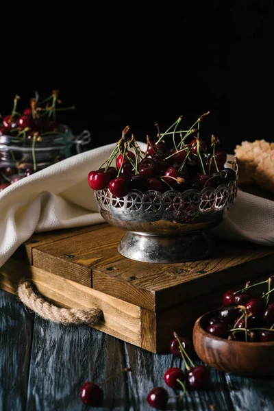 Vista de cerca de cerezas orgánicas dulces en un tazón vintage sobre una mesa de madera - foto de stock
