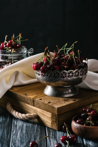 Vista de cerca de cerezas frescas maduras en un tazón vintage sobre una mesa de madera - foto de stock