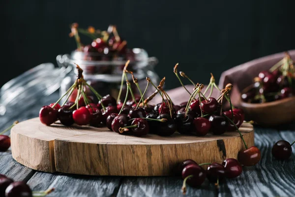 Vista de cerca de cerezas dulces maduras frescas sobre tabla de cortar de madera - foto de stock