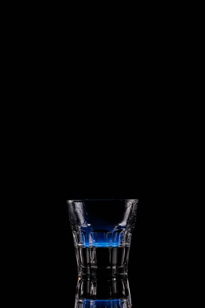 Vue rapprochée de l'alcool sambuca boisson brûlant dans le verre sur fond noir — Photo de stock