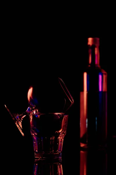 Close up view of bottle and glasses with sambuca alcohol drink on black background — Stock Photo