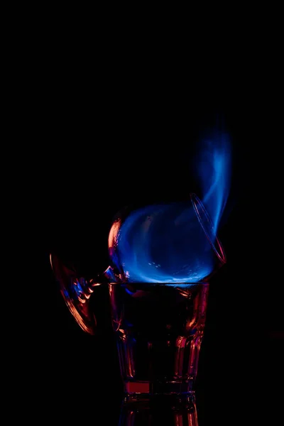 Близкий вид спирта самбука напиток горящий в стекле на черном фоне — стоковое фото