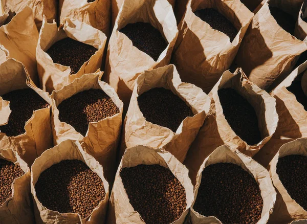 Sacs en papier artisanal avec grains de café fraîchement torréfiés — Photo de stock